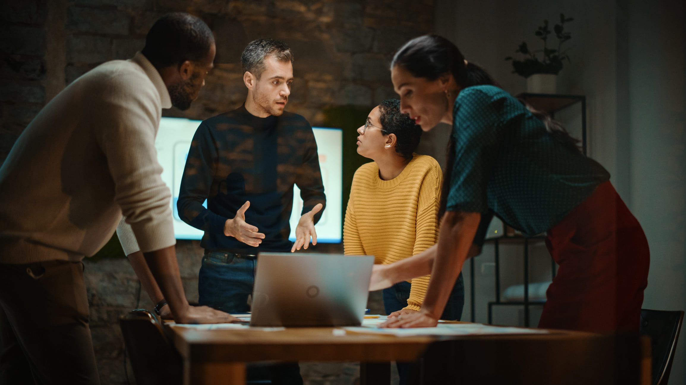 Team discussing in a dimly lit office.