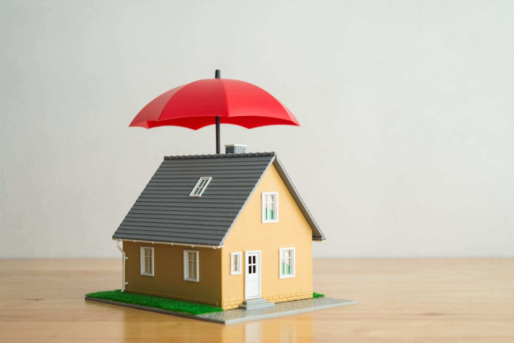 Model house under a red umbrella.