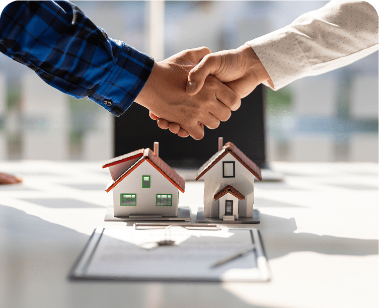 Handshake over miniature house models and contract.