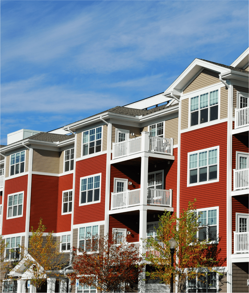 Red and beige apartment building under sky.