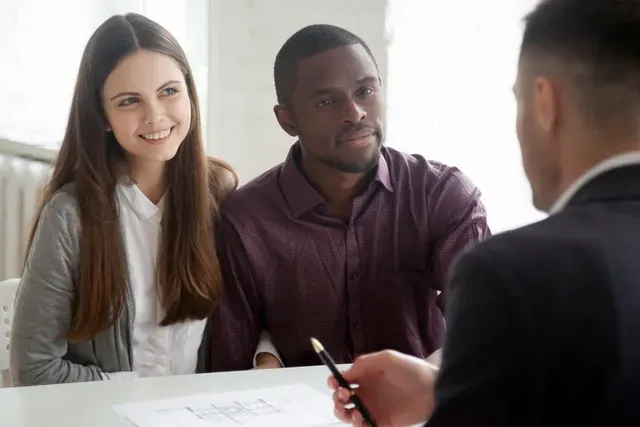 Two professionals attentively listening during a business meeting.