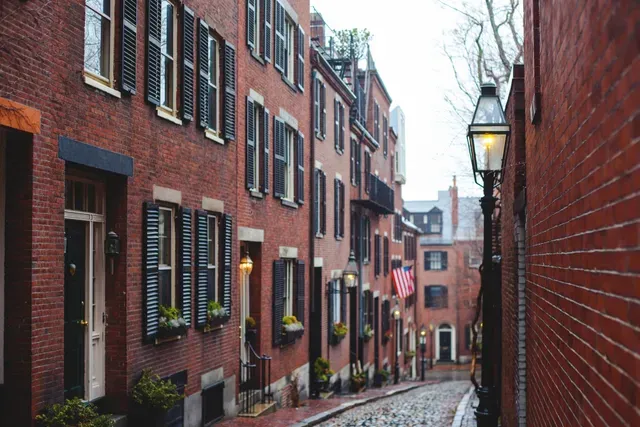 Charming cobblestone street with brick buildings and flower boxes.