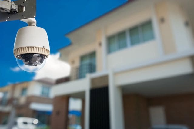 A security camera mounted outside a building on a clear day.