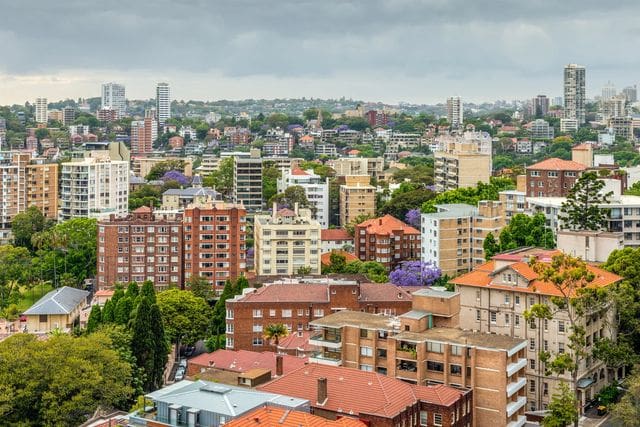 A cityscape with diverse buildings under a cloudy sky.